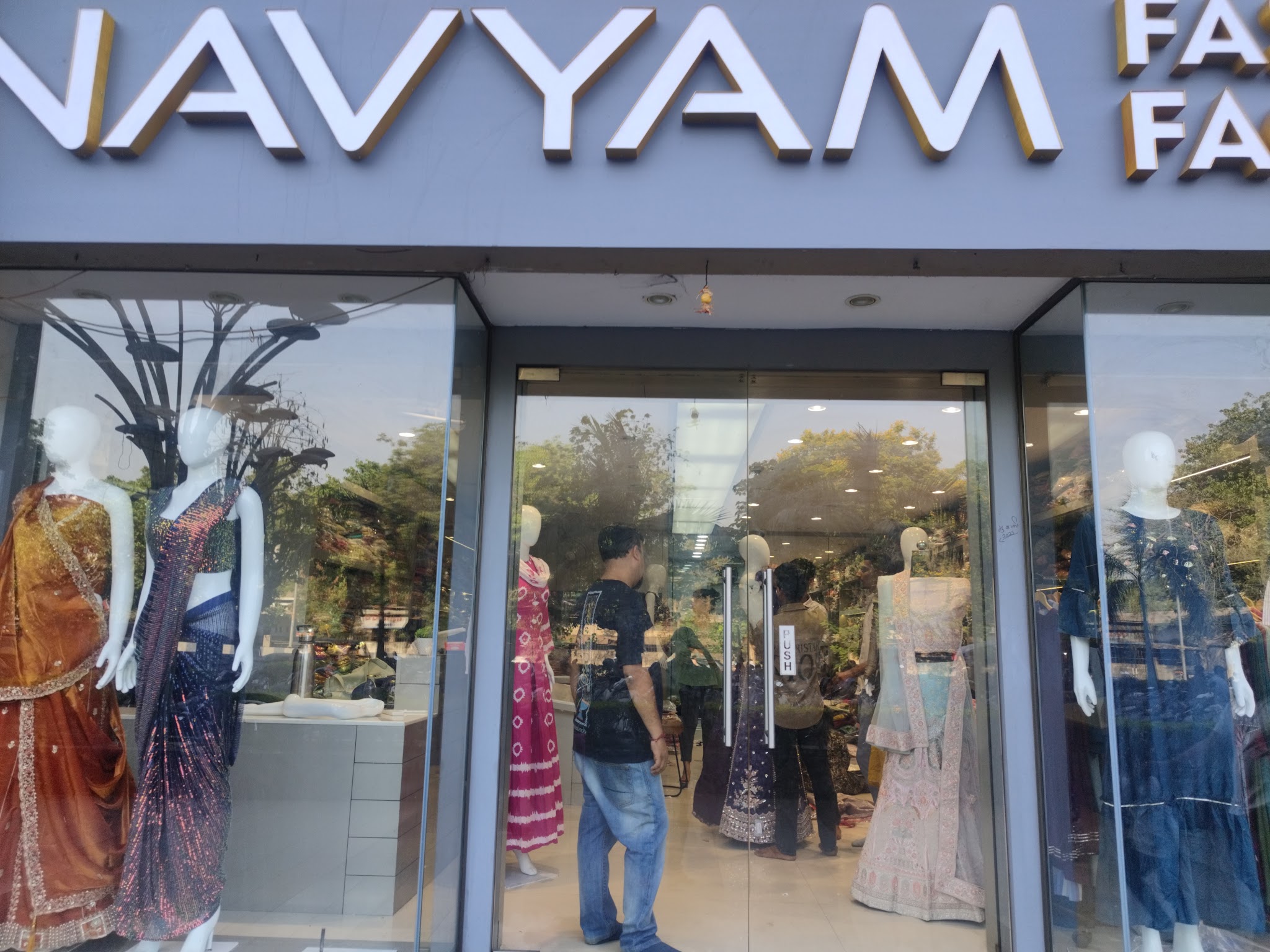Navyam Fashion Surat storefront with mannequins in the display windows.