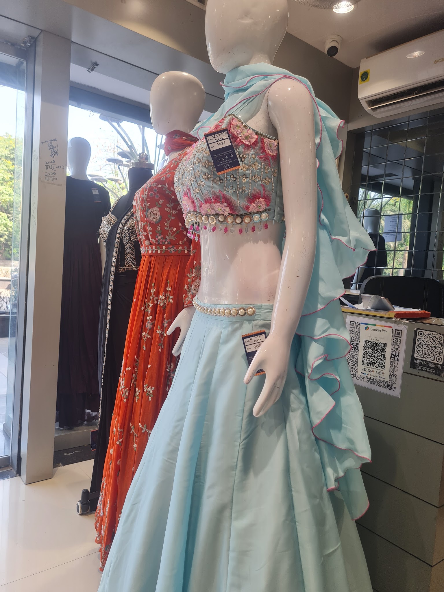 Embellished celebration outfits displayed on mannequins in the showroom.